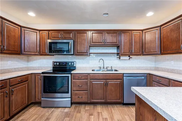 a kitchen with stainless steel appliances granite countertop a sink stove and cabinets