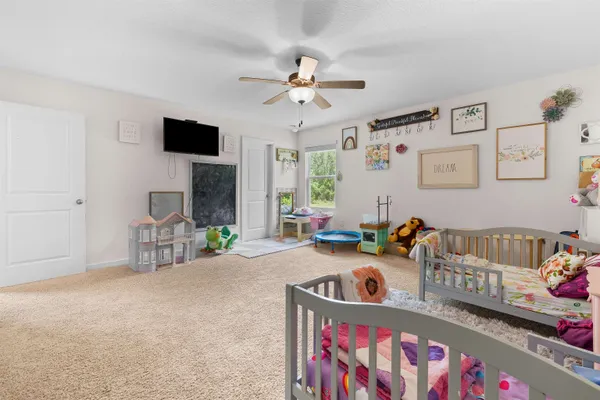 a bedroom with furniture a rug and a flat screen tv