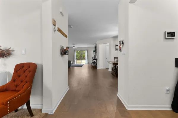 a hallway with a couch and a dining table next to a window