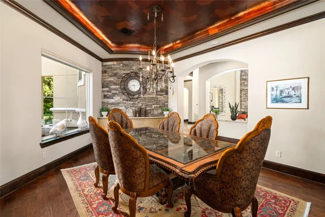 a dining room with furniture a chandelier and wooden floor