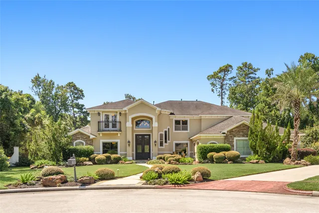a front view of a house with a yard and potted plants
