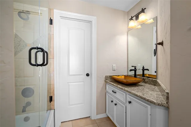 a bathroom with a granite countertop sink and a mirror