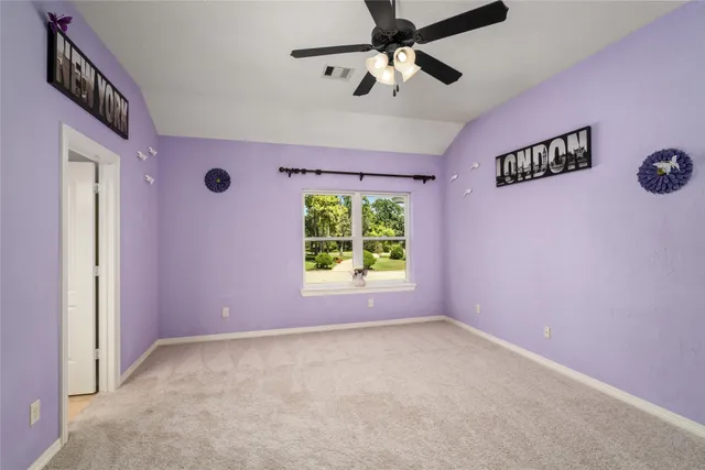 an empty room with windows and fan