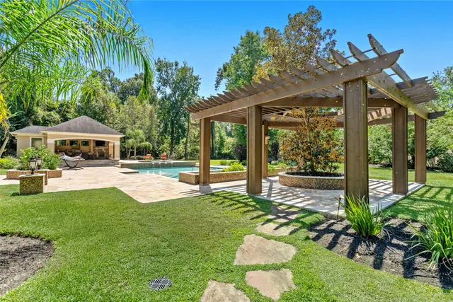 a view of house with garden and tall trees