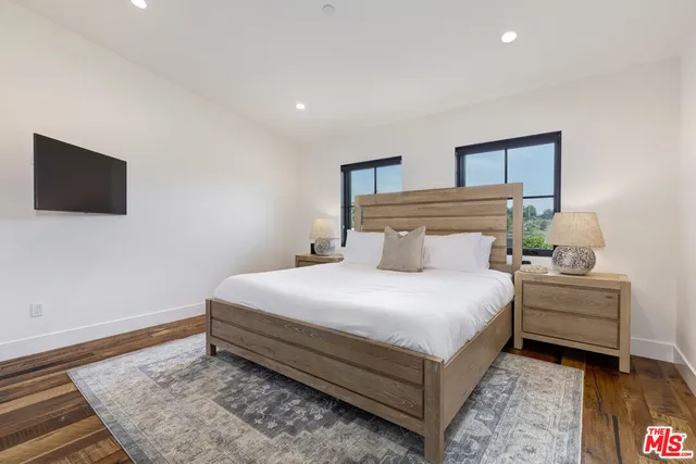 a bedroom with a bed and a flat screen tv