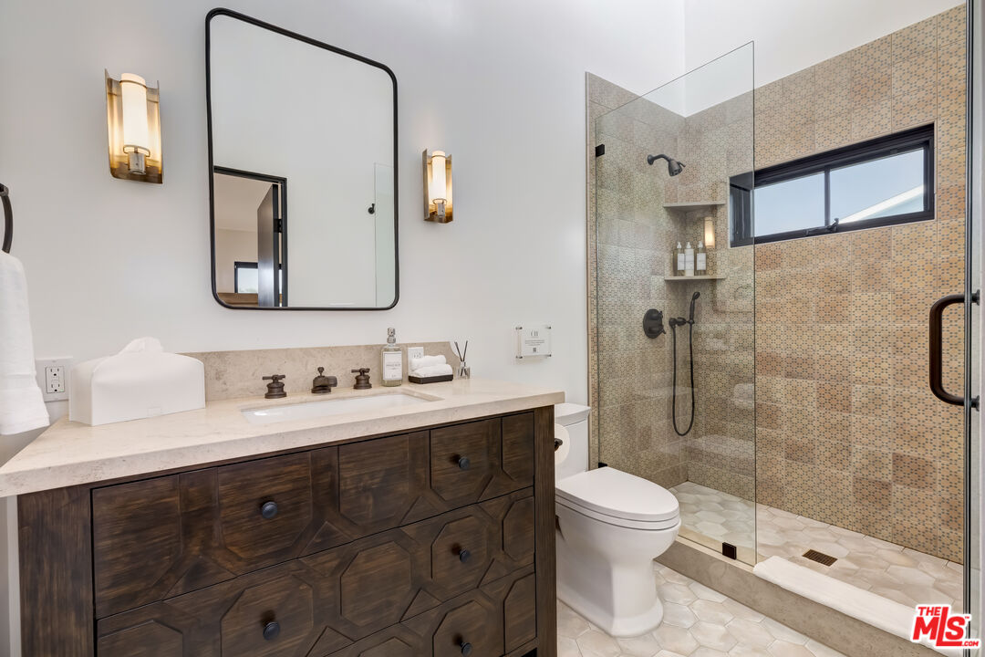 6711 Wandermere Road Malibu, CA 90265 - Photo 21 of 27 a bathroom with a toilet a sink a mirror and a shower