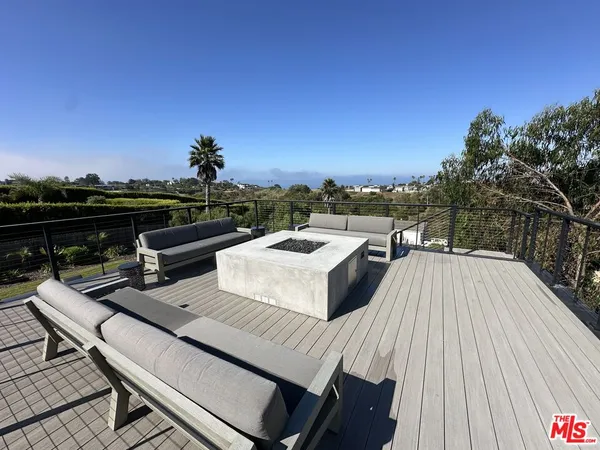 a roof deck with couches and wooden floor