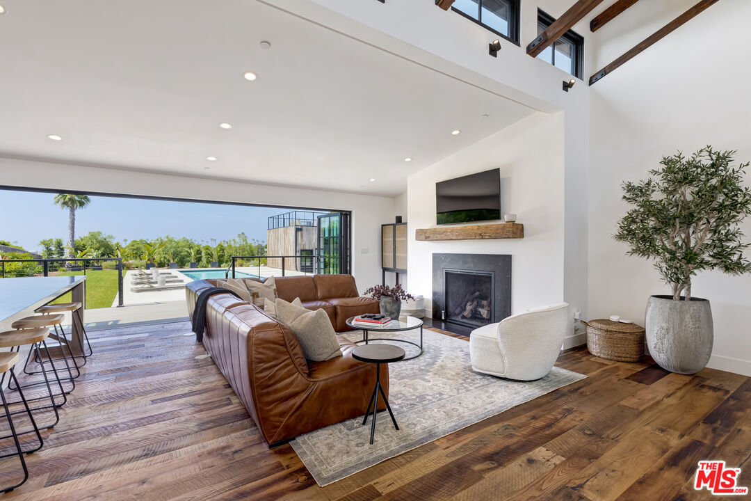 6711 Wandermere Road Malibu, CA 90265 - Photo 26 of 27 a living room with furniture a fireplace and a flat screen tv