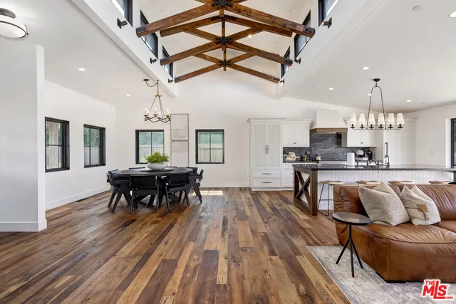 a kitchen with stainless steel appliances granite countertop lots of furniture and wooden floors