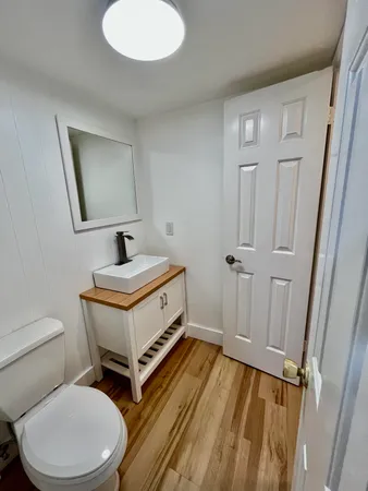 a bathroom with a toilet a sink and mirror