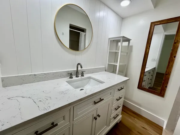 a bathroom with a granite countertop sink toilet and shower