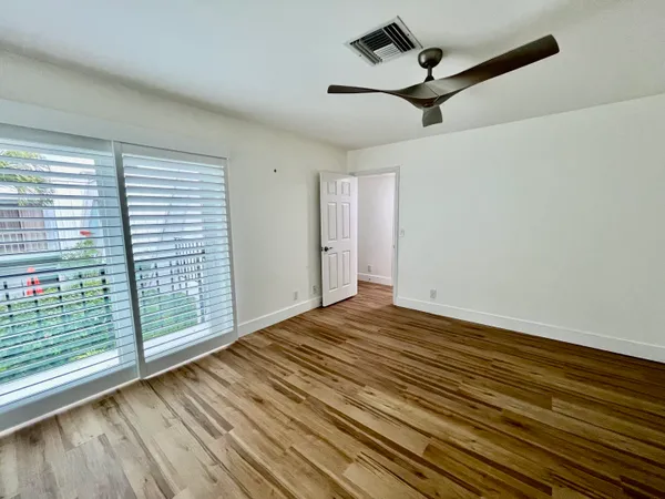 a view of a room with wooden floor and a ceiling fan