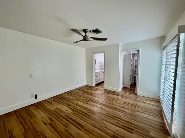 a view of a livingroom with wooden floor and a ceiling fan
