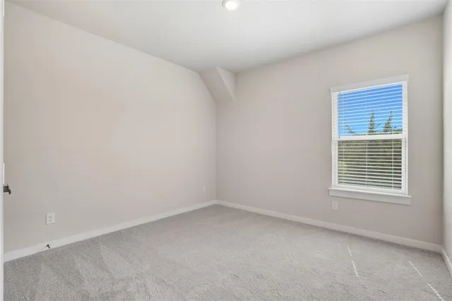 an empty room with a window and a ceiling fan
