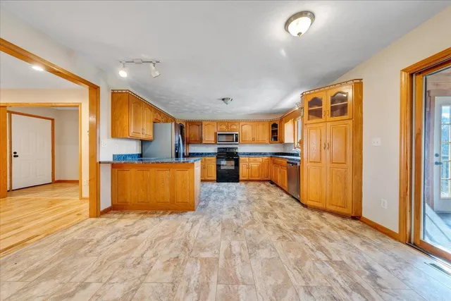 a large kitchen with stainless steel appliances granite countertop a refrigerator and a stove top oven