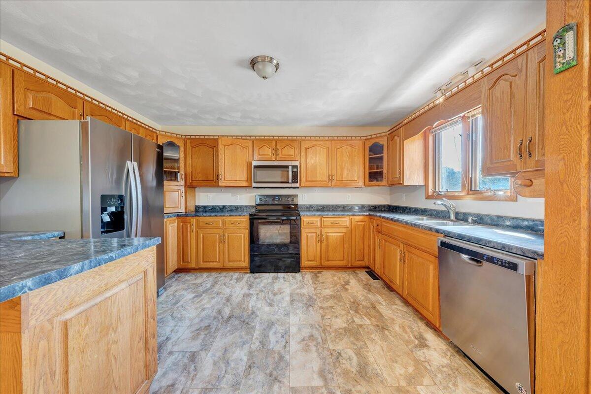 1296 3 Oaks Road Wirtz, VA 24184 - Photo 17 of 59 a large kitchen with stainless steel appliances granite countertop a stove a sink dishwasher a refrigerator and a microwave oven