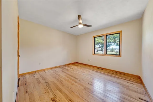 a view of a big room with wooden floor and windows