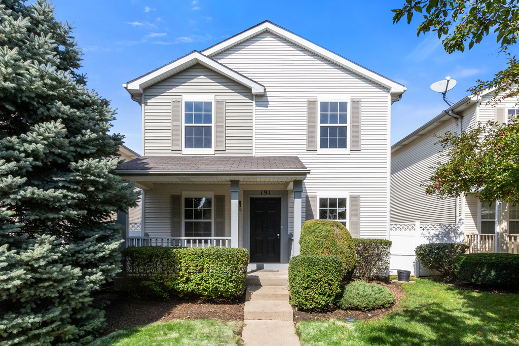 a view of a white house next to a yard