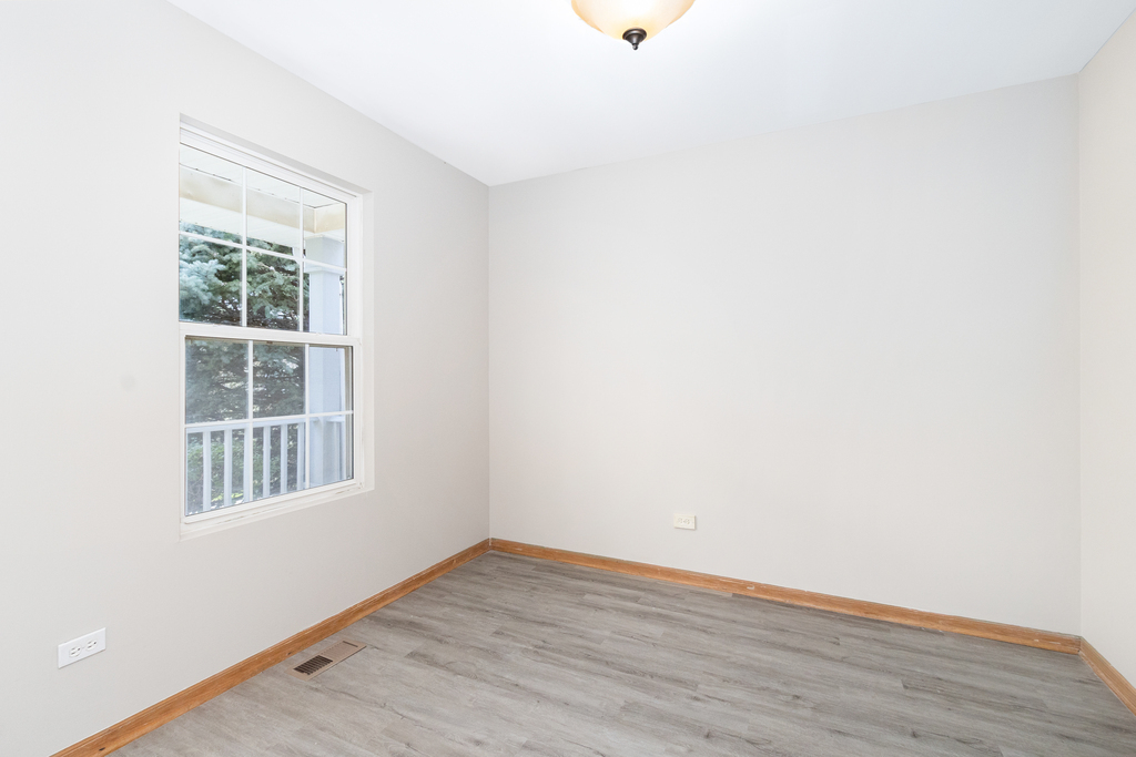 191 Mountain Laurel Court Romeoville, IL 60446 - Photo 18 of 25 a view of an empty room with wooden floor and a window