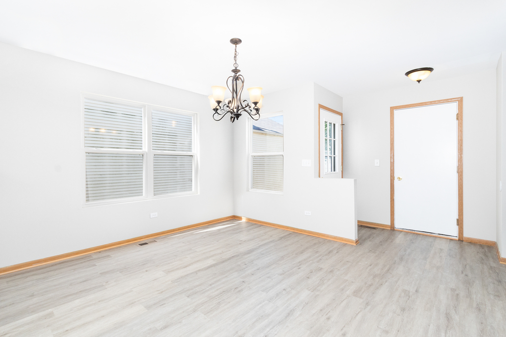 191 Mountain Laurel Court Romeoville, IL 60446 - Photo 3 of 25 an empty room with wooden floor and windows