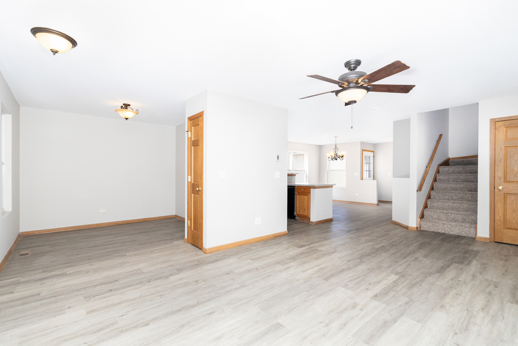 191 Mountain Laurel Court Romeoville, IL 60446 - Photo 4 of 25 a view of a livingroom with wooden floor and a ceiling fan