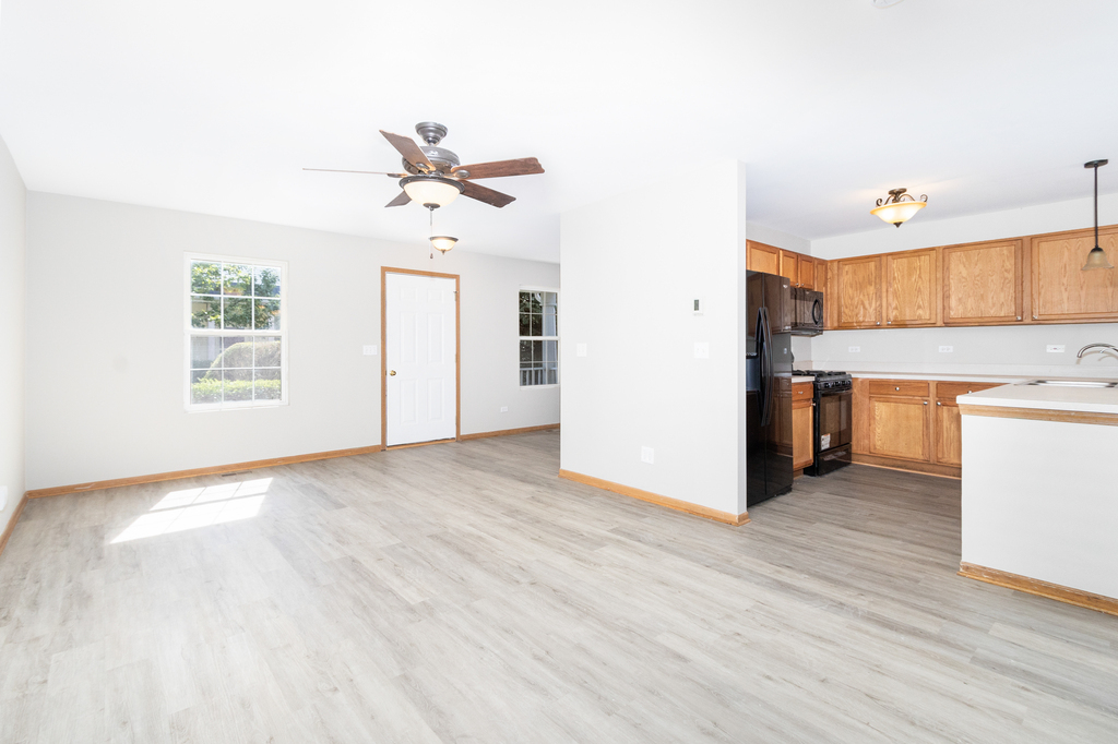 191 Mountain Laurel Court Romeoville, IL 60446 - Photo 5 of 25 a view of a kitchen with wooden floor and a ceiling fan