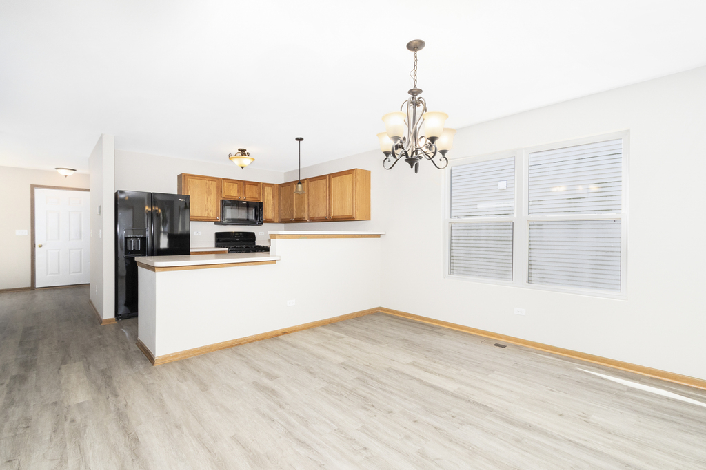 191 Mountain Laurel Court Romeoville, IL 60446 - Photo 10 of 25 a view of a kitchen with a dishwasher cabinets and a wooden floor
