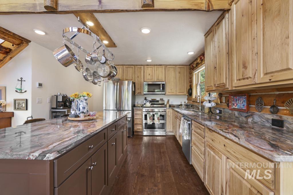 65 Goat Creek Way Stanley, ID 83278 - Photo 14 of 32 Kitchen featuring a large central island with a stone countertop, wood-finish flooring, recessed lighting, natural wood cabinetry, and stainless steel appliances
