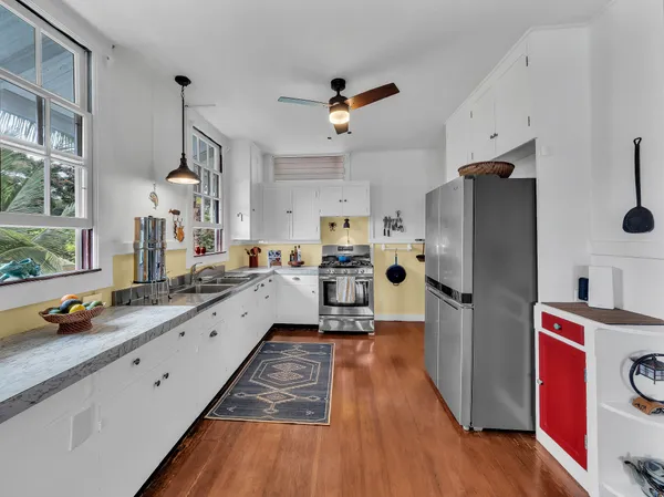 a kitchen with refrigerator a stove and wooden floor