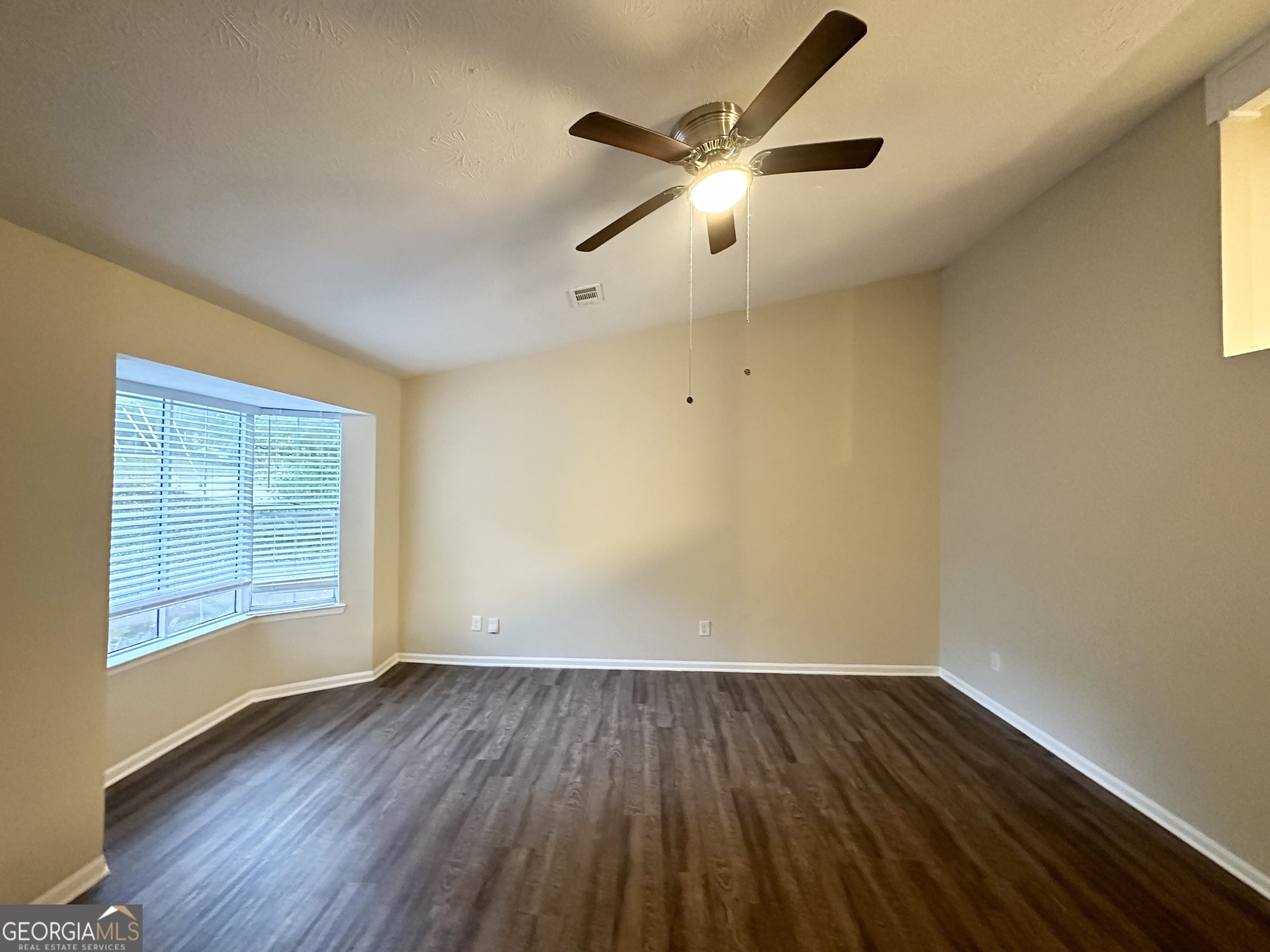 3865 Lehigh Boulevard Decatur, GA 30034 - Photo 3 of 19 an empty room with wooden floor chandelier fan and windows