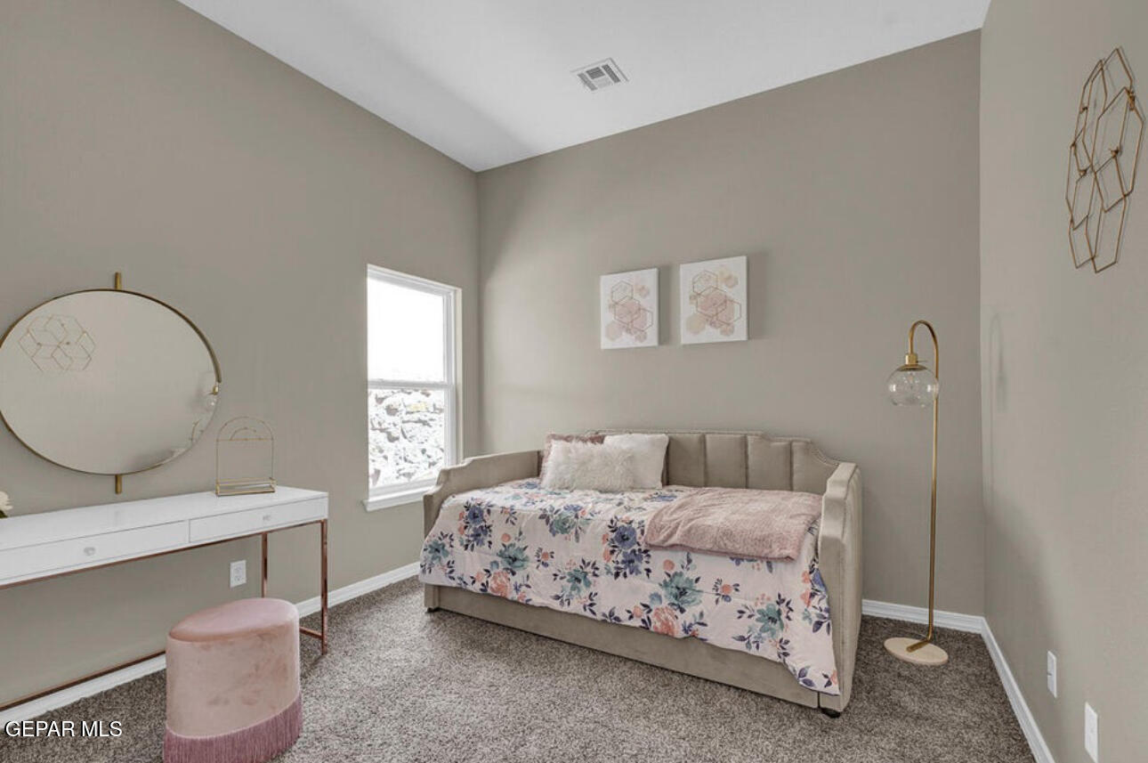 12434 Fill Ball Street El Paso, TX 79928 - Photo 25 of 32 a bedroom with a bed a mirror and a window