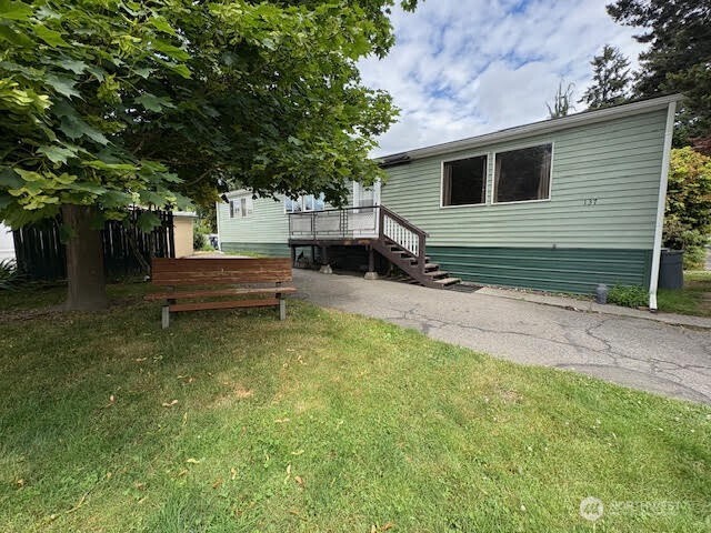 a view of backyard with wooden fence and a large tree