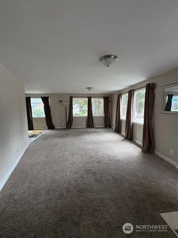 a view of an empty room with windows and closet