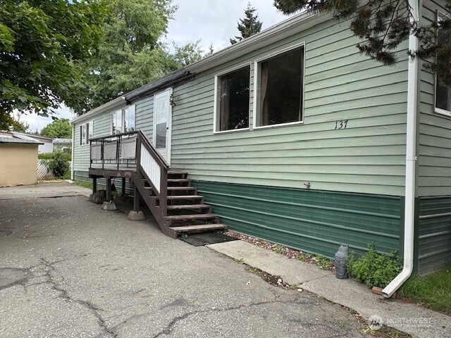 7301 Northeast 175th Street, Unit 137 Kenmore, WA 98028 - Photo 2 of 24 a back view of a house with a yard
