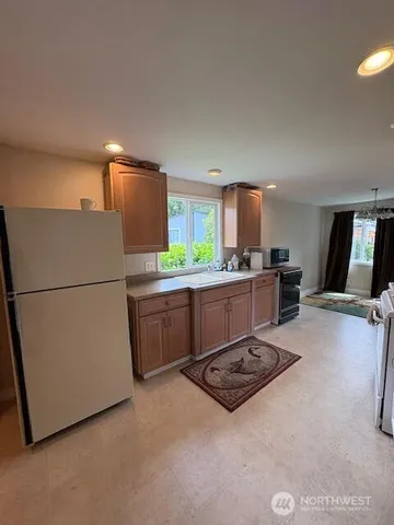 a kitchen with stainless steel appliances a refrigerator sink and white cabinets