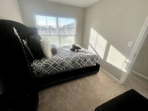 a bedroom with a bed next to a window