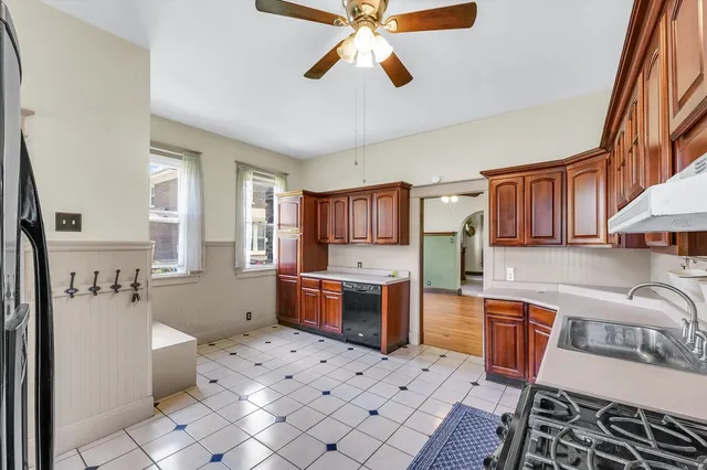 a kitchen with stainless steel appliances a stove a sink a refrigerator cabinets and dining table