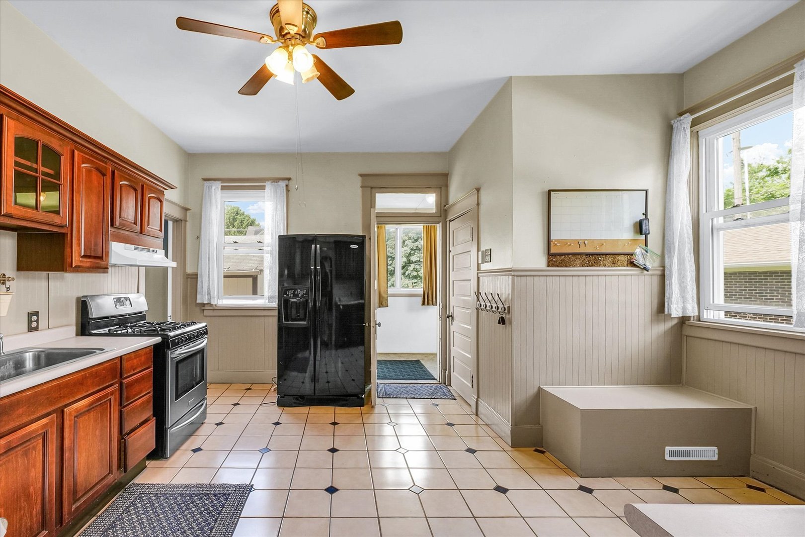 301 North Main Street Fithian, IL 61844 - Photo 21 of 53 a kitchen with stainless steel appliances a refrigerator a stove a sink a dining table and chairs with wooden floor
