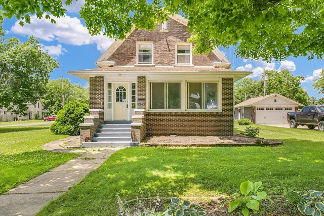 a front view of a house with a yard and trees