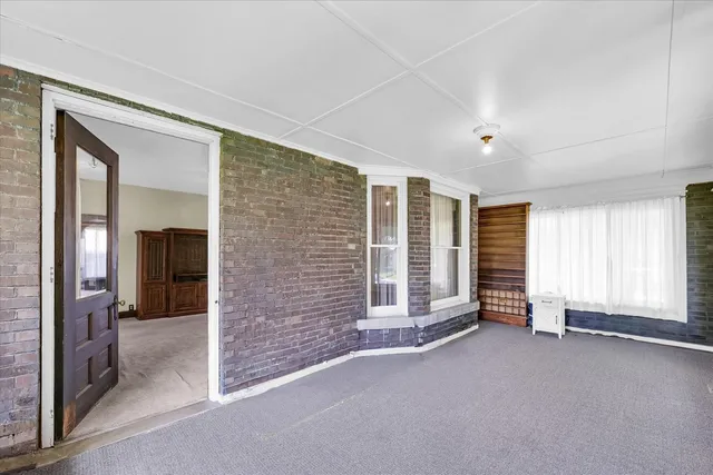 a view of an empty room with a fireplace and a window