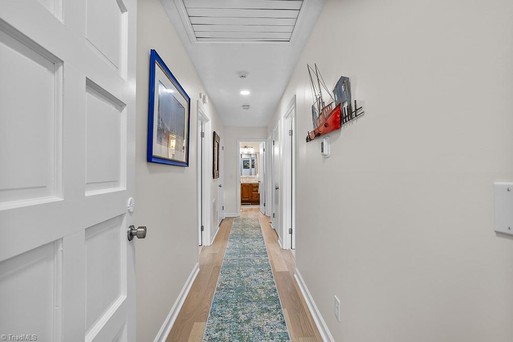 120 Buckhaven Court Rural Hall, NC 27045 - Photo 26 of 47 Off of the great room, you'll find an expansive hallway where the primary suite, 2 more large bedrooms, another full bathroom, and 2 storage closets reside.