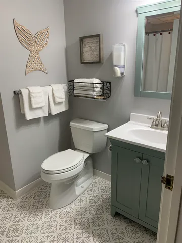a bathroom with a toilet sink and mirror
