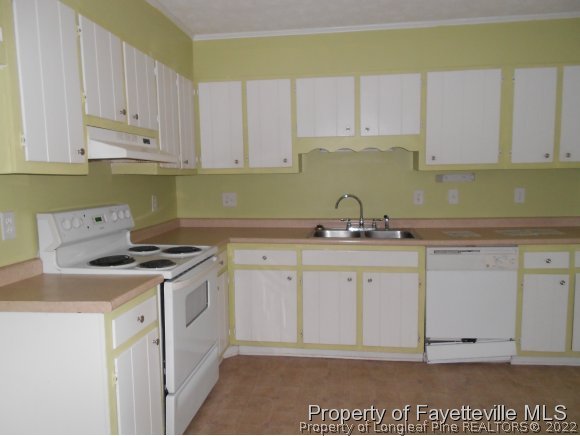 5862 Columbine Road Fayetteville, NC 28306 - Photo 4 of 10 a kitchen with granite countertop white cabinets and white appliances