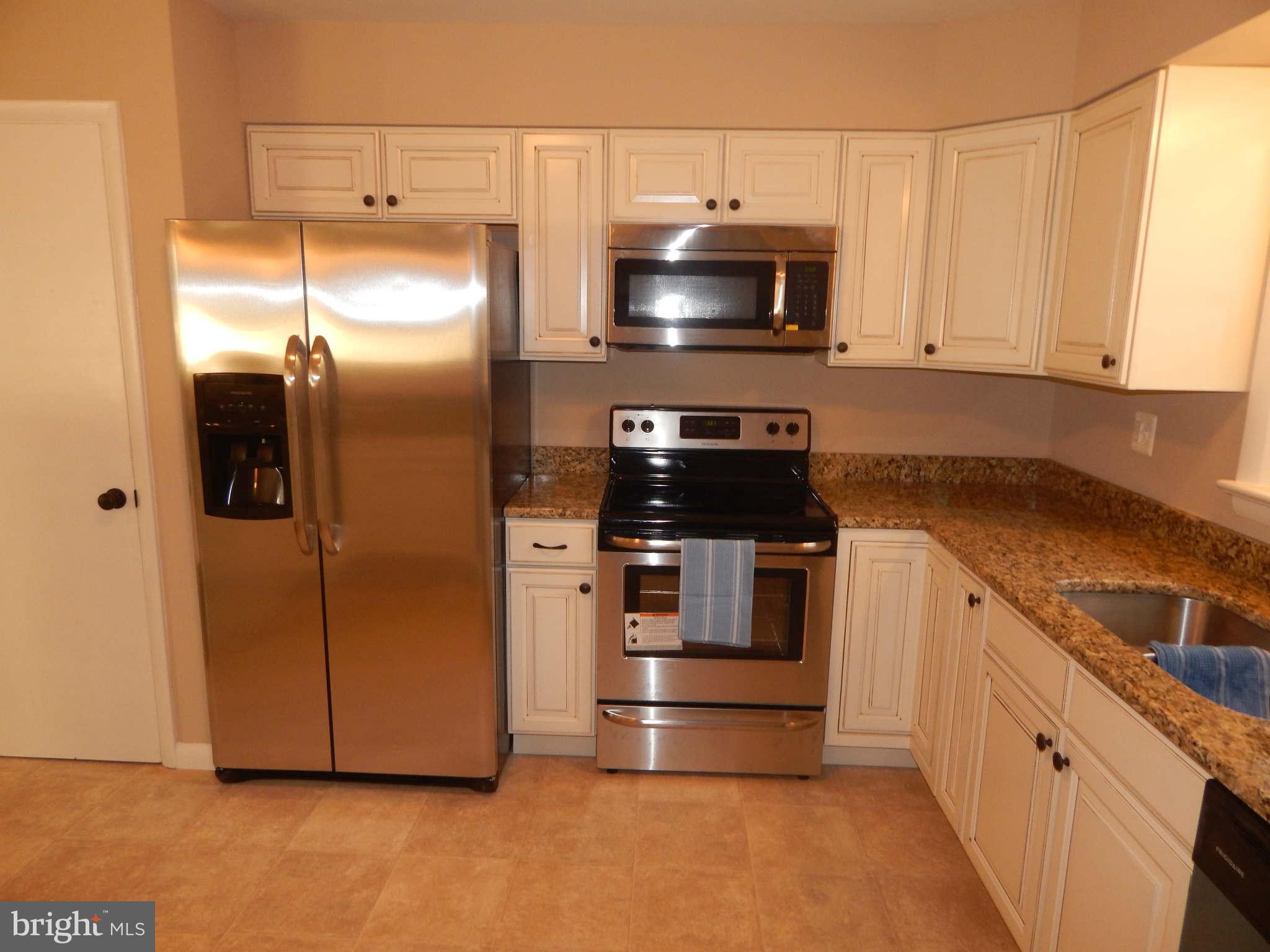 8515 Schultz Road Clinton, MD 20735 - Photo 8 of 30 a kitchen with kitchen island granite countertop a stove and a refrigerator