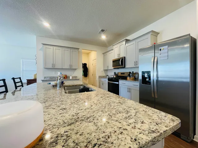 a kitchen with sink refrigerator and microwave