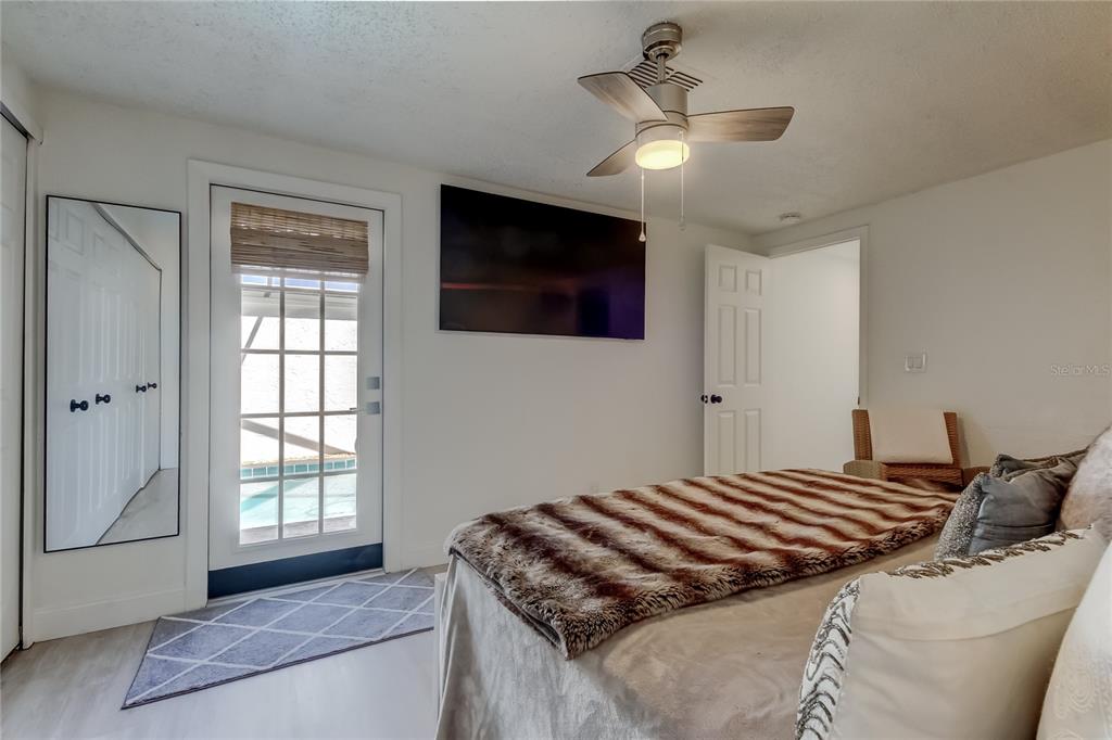 12625 Shell Point Drive Hudson, FL 34667 - Photo 39 of 61 a bedroom with a large bed and a flat screen tv