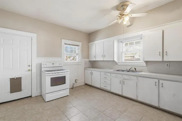 a kitchen with granite countertop white cabinets white stainless steel appliances with a sink and dishwasher
