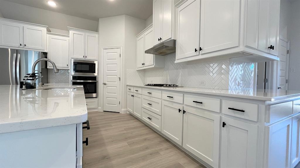 5304 Babcock Road McKinney, TX 75071 - Photo 3 of 27 a kitchen with stainless steel appliances white cabinets and a stove a refrigerator with white cabinets