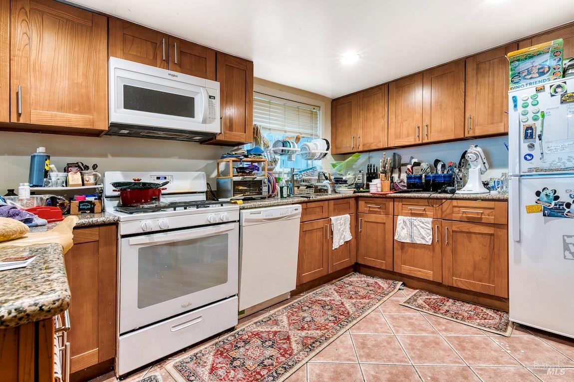 1128 Chester Street Oakland, CA 94607 - Photo 31 of 42 a kitchen with stainless steel appliances granite countertop a stove microwave and cabinets