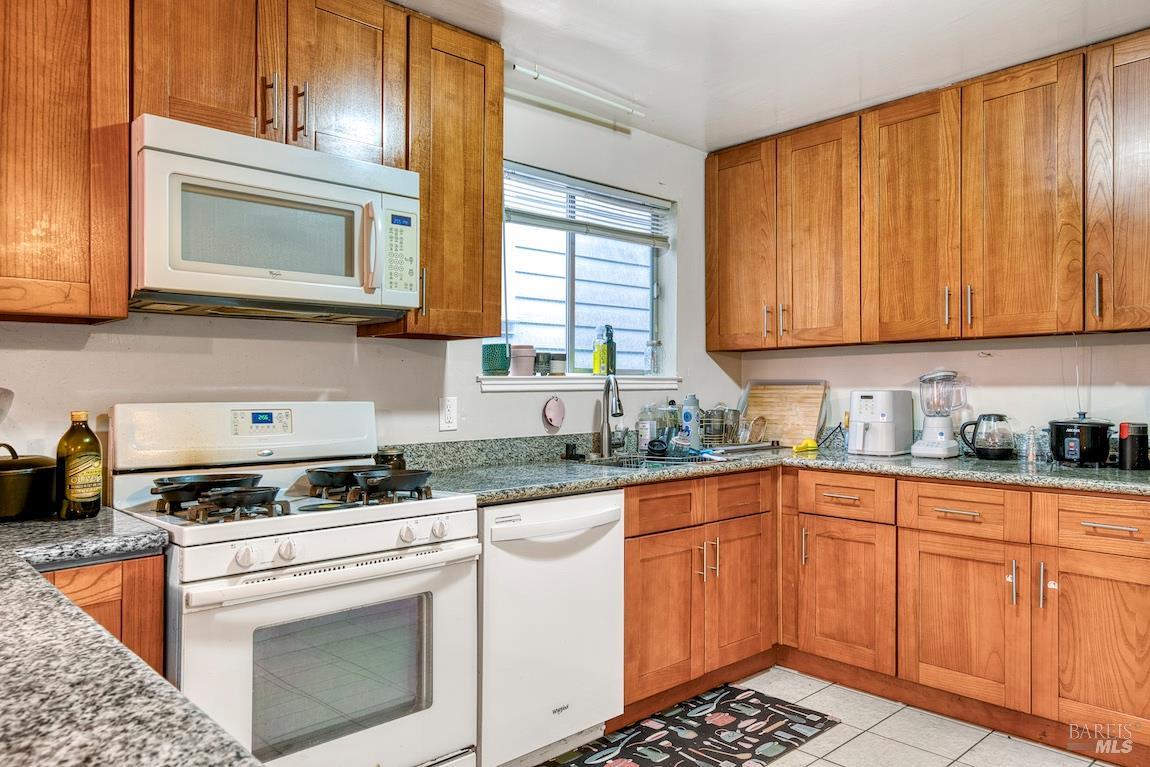 1128 Chester Street Oakland, CA 94607 - Photo 10 of 42 a kitchen with granite countertop cabinets stainless steel appliances a sink and a window